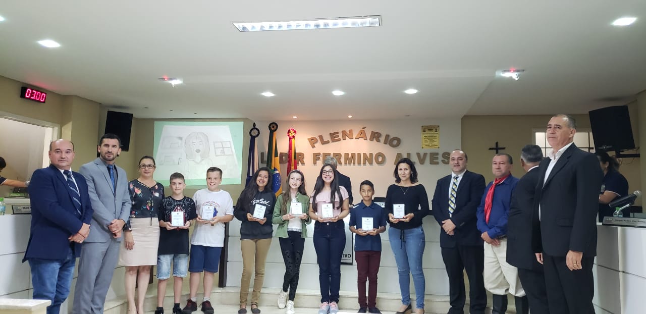 Vereadores: Valdir Machado, Cleomar Gnoatto, Luzia Barbosa Netto, Valmir Dall'Agnoll, Hanilton João Venério e Jorge Luiz Nicolau entregam a homenagem pelo terceiro lugar nacional Esquete Teatral.