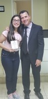 Vereador Fabio Júnior Ramos entrega a homenagem a aluna Fernanda de Lima pelo sétimo lugar nacional na Categoria Desenho.